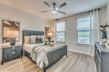 Spacious bedroom with two windows and decorative furnishings